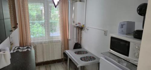 a small kitchen with a small table and a microwave at LCB Apartments C04 in Târgu-Mureş