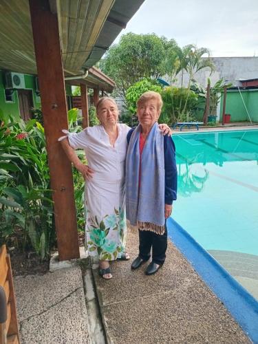 two older women standing next to a swimming pool at Hotel Santa Helena in Leticia