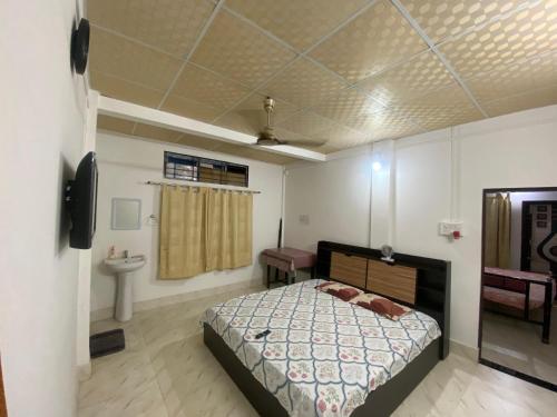 a bedroom with a bed and a sink in it at dibrugarh guest house in Dibrugarh