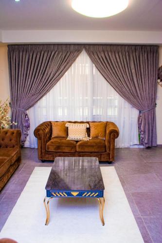 a living room with a couch and a coffee table at Perf Deluxe in Accra