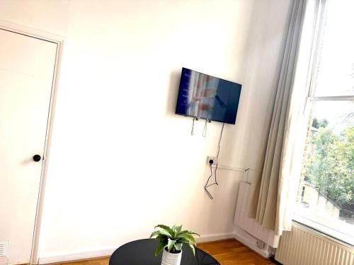 a living room with a flat screen tv on a wall at One Bedroom Flat A in Kentish Town in London