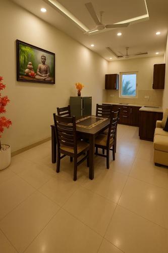 a dining room with a table and chairs at Pearl Grand Boutique Cottage in Omaxe Anandam Vrindavan - #premium AC rooms with balcony #big parking #lift #garden #peaceful area #near prem mandir #property of the year #most awarded in Vrindāvan