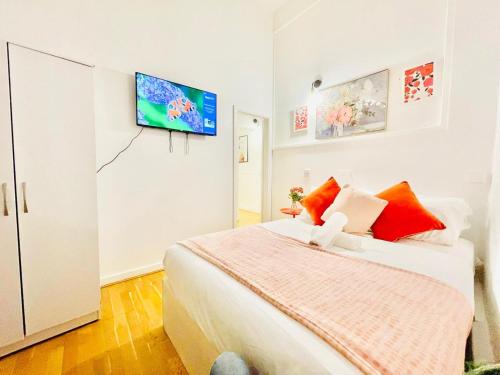 a bedroom with a bed and a flat screen tv on the wall at One Bedroom Flat A in Kentish Town in London