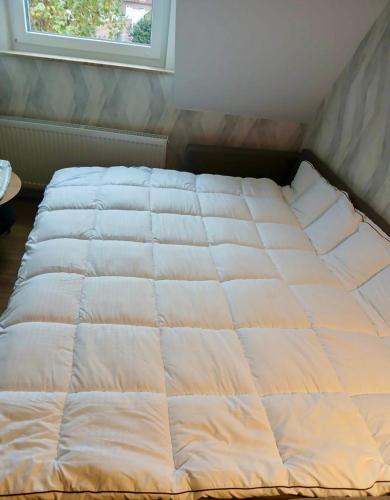 a white bed in a room with a window at GW Apartment 2 in Meppen