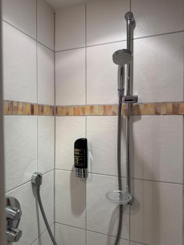 a shower with a phone in a bathroom at LuCA Hotel in Bodenmais