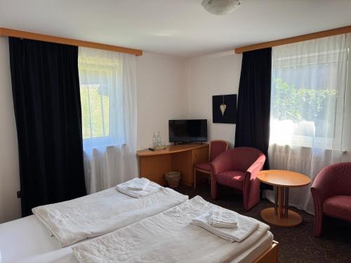 a hotel room with two beds and two chairs at LuCA Hotel in Bodenmais