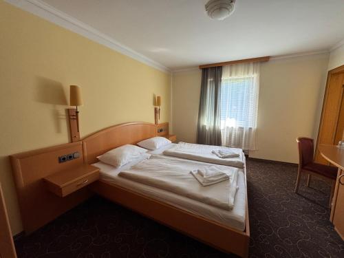 a hotel room with a bed and a window at LuCA Hotel in Bodenmais