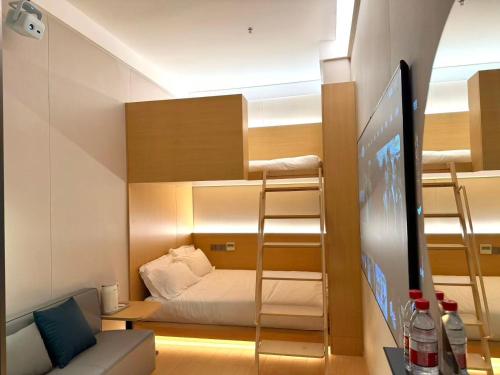 a small room with a bunk bed and a tv at 船长五号青年酒店-上海中山公园江苏路地铁站店 in Shanghai