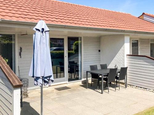 a patio with a table and a white umbrella at 4 person holiday home in Ærøskøbing-By Traum in Ærøskøbing