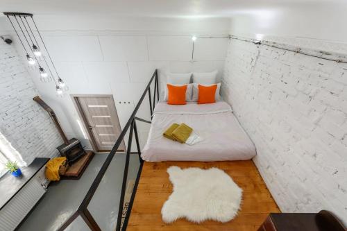 a small room with a bed with orange pillows at Простора квартира в центрі міста біля площі Філармонії in Chernivtsi