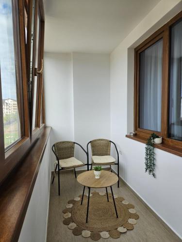 a room with two chairs and a table and a window at Tei Residence in Piatra Neamţ