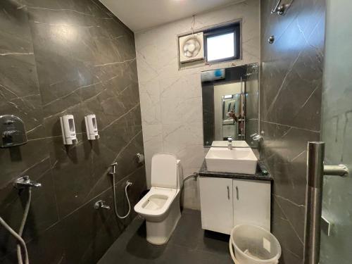 a bathroom with a toilet and a sink at Yatram in Rishīkesh