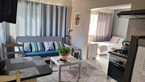 a living room with a blue couch and a table at Senelle accomodation in Hermanus
