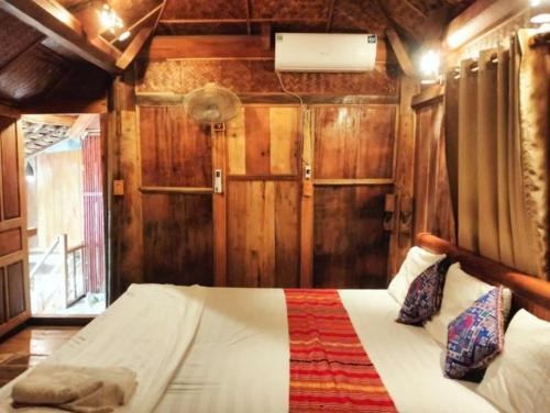 a bedroom with a bed in a room with wooden walls at Homestay Hoanh Thắng in Lũng Tiềm