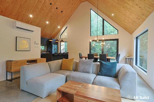 een woonkamer met een bank en een tafel bij Oslo Scandinavian Getaway Spa & Pet-Friendly in Saint Come