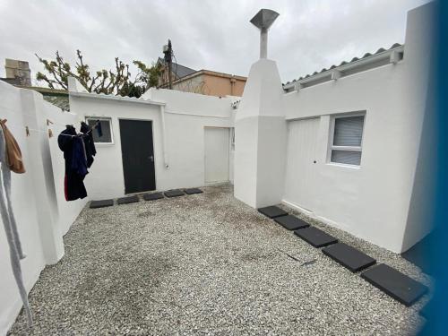 a white house with a courtyard and a door at House Grace in Gqeberha