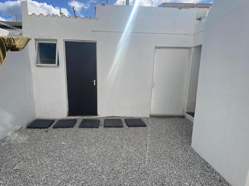 a white building with a door and a rainbow at House Grace in Gqeberha