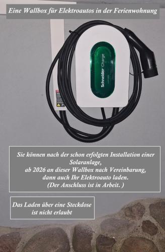a sign with a hose attached to a plug at Waldesruh Strausberg in Strausberg
