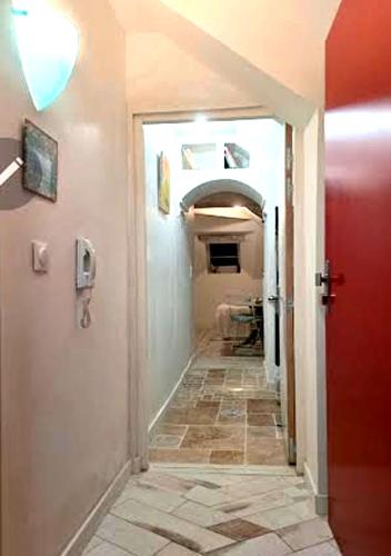 a hallway with a red door and a tile floor at L'Étoile in Moret-sur-Loing
