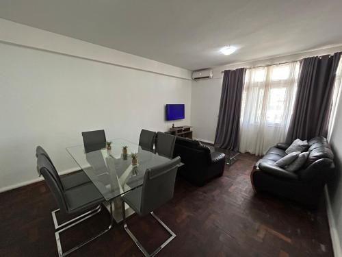 a living room with a glass table and chairs at Two-bedroom apartment - Spacious, with a gym and well-equipped in Beira