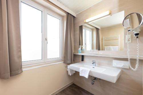 a bathroom with a sink and a mirror at Hotel Landliebe in Söchau