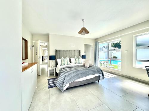 a bedroom with a bed and a view of the ocean at Adrift Guesthouse in St Francis Bay
