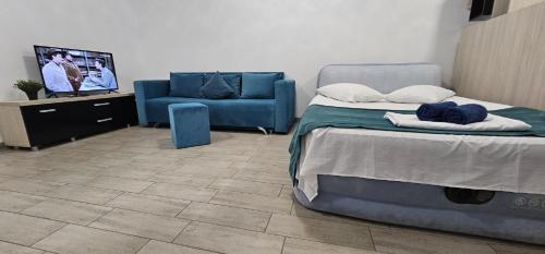 a bedroom with a bed and a blue couch at Beach Pool & Spa Resort Mamaia Nord Alezzi piscina incalzita in Mamaia Nord