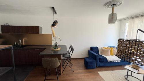a kitchen and a living room with a blue couch at Splendide Appart’ près de Disney in Montévrain
