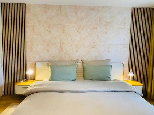 a white bed with two pillows and two lamps at Kandelblick in Waldkirch