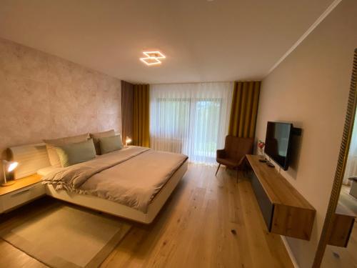 a bedroom with a large bed and a television at Kandelblick in Waldkirch