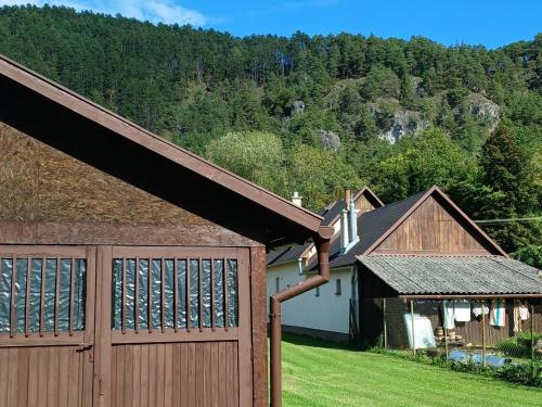 a house with a wooden fence and a garage at Apartmán pri Gaderskej bráne in Blatnica