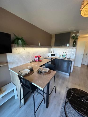 a kitchen with a table with chairs and a counter top at Studio cosy in Balaruc-les-Bains