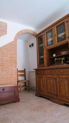 a room with a large wooden cabinet and a chair at La Piastraia in Parlascio
