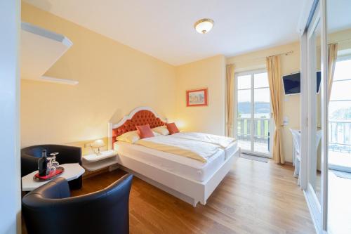 a bedroom with a bed and a balcony at Privatzimmer Stabauer in Mondsee