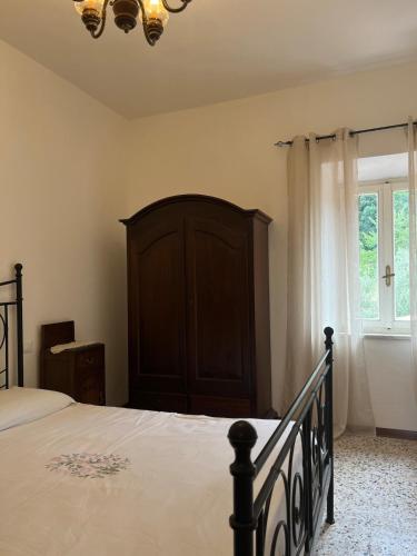 a bedroom with a bed with a wooden headboard and a window at La Piastraia in Parlascio