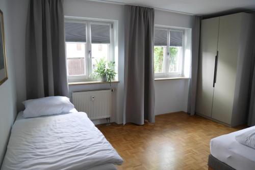 a small bedroom with two beds and two windows at Ferienwohnung Naznhaus in Windischeschenbach