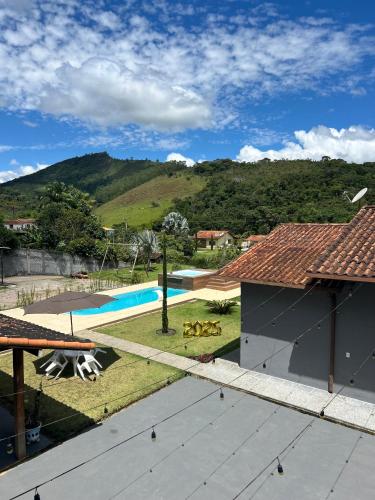 a house with a swimming pool and a mountain at Sitio Real Cascata in Teresópolis
