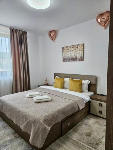 a bedroom with a bed with two towels on it at Tei Residence in Piatra Neamţ