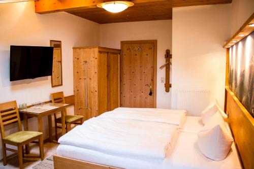 a bedroom with a bed and a table and a desk at Haus Brigitte in Nauders