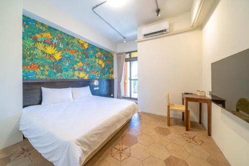 Un dormitorio con una cama y un cuadro en la pared. en Yunhua B&B, en Hualien City
