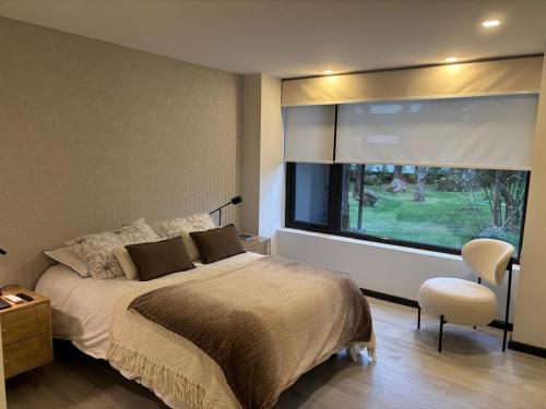 a bedroom with a bed and a large window at Pucón Infinity Camino al Volcán in Pucón