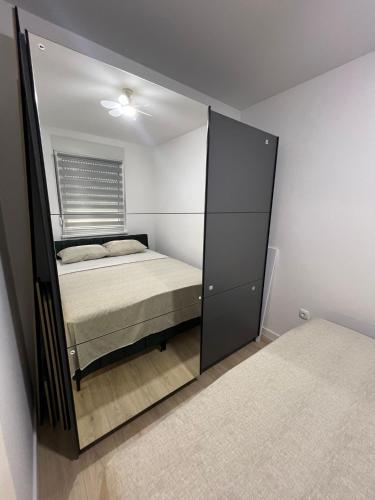 a mirror reflection of a bed in a bedroom at Lux Iva apartman in Doboj