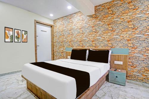 una cama en una habitación con una pared de ladrillo en Hotel O N R, en Ahmedabad
