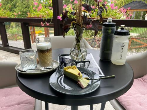 a black table with a piece of cake and a drink at Apartmán Hora in Muránska Huta