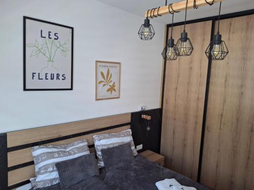 a bedroom with a bed with two lights and pillows at Apartman Zlatibor in Zlatibor