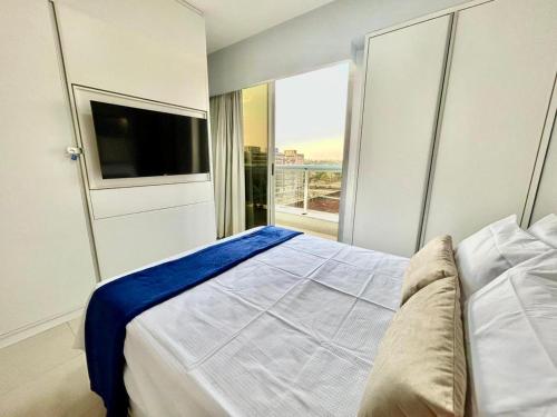 a bedroom with a bed and a large window at Apartamento com Piscina - Melhor Localização in Brasilia