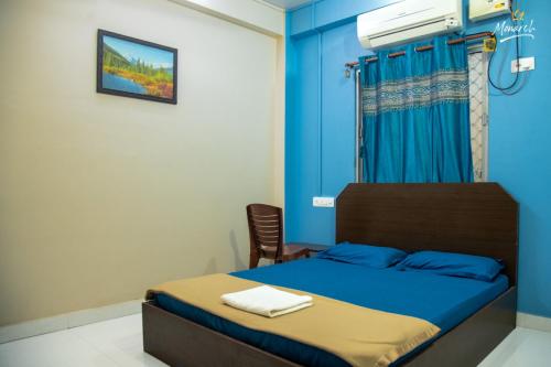 une chambre avec un lit avec un mur bleu dans l'établissement Monarch Homestay, à Jangli Ghāt