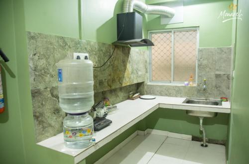 une bouteille d'eau posée sur un comptoir de cuisine dans l'établissement Monarch Homestay, à Jangli Ghāt