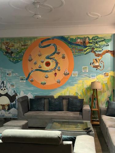 a living room with a large mural on the wall at Haven On Hill - Rishikesh in Rishīkesh