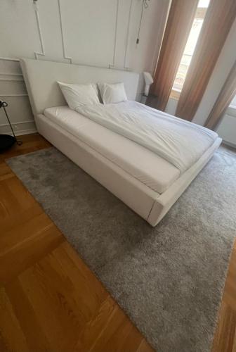 a white bed in a room with a rug at Niedras place in Degole